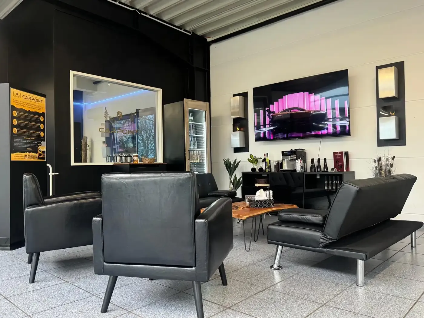 Wartebereich mit Sesseln, Kaffee und Fernseher bei PR Carpoint