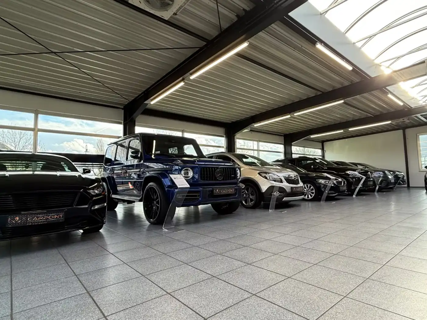 Mercedes-AMG G 63 und Ford Mustang in der Ausstellungshalle von PR Carpoint
