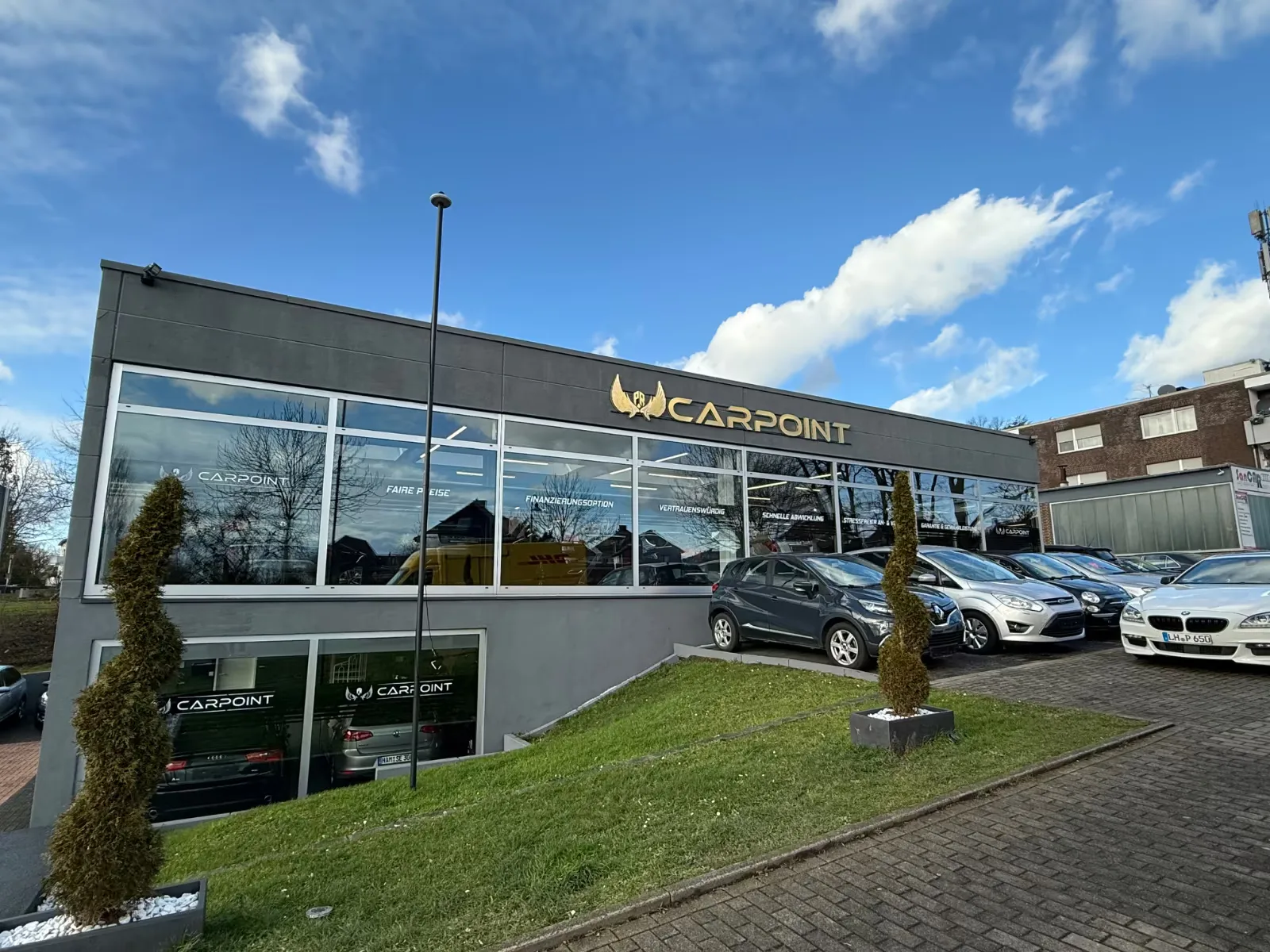 Das Autohaus PR Carpoint von der Straße aus, davor die Fahrzeugreihe auf dem Vorplatz